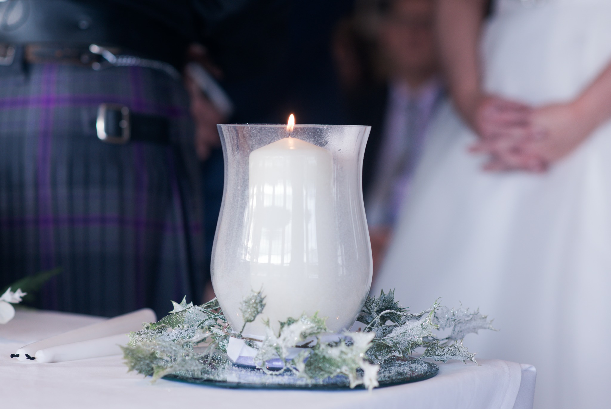 A Scotish wedding with a white candle.