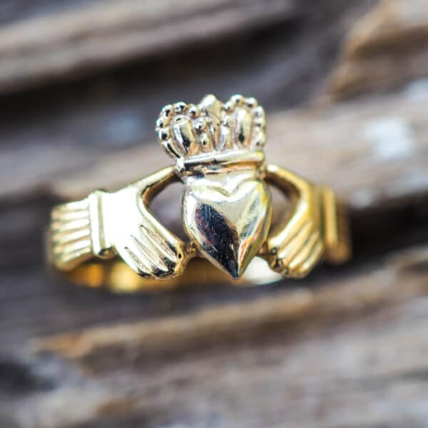 A gold claddagh ring with a crown and heart.